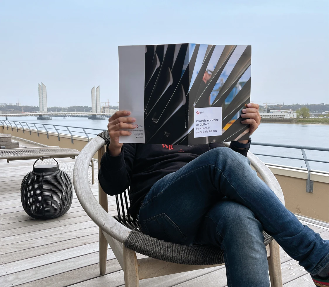 Lecteur du magazine de Golfech sur terrasse à Bordeaux Pont Chaban Delmas Garonne